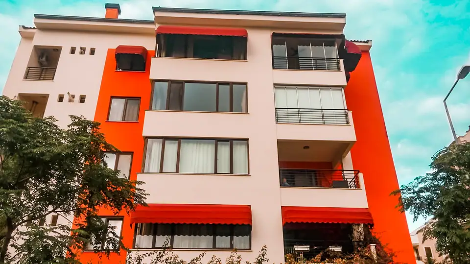 Apartman balkonlarında kırmızı körüklü tenteler