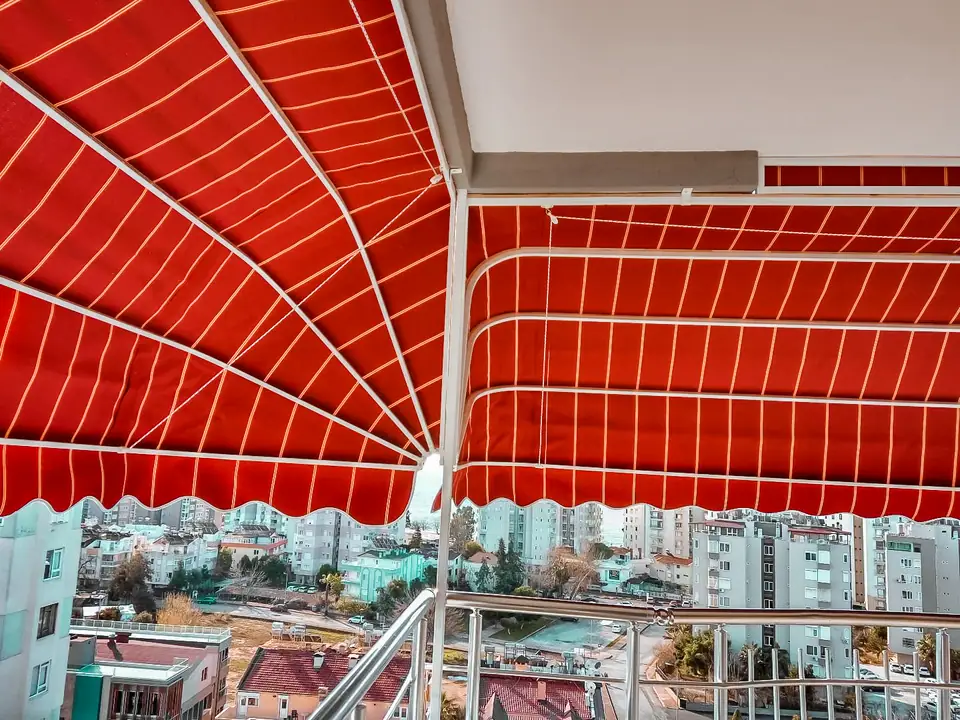 Balkonda kırmızı körüklü tente, alttan görünüm